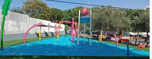 Frontal view of a splash pad with slip resistant flooring with blue colors